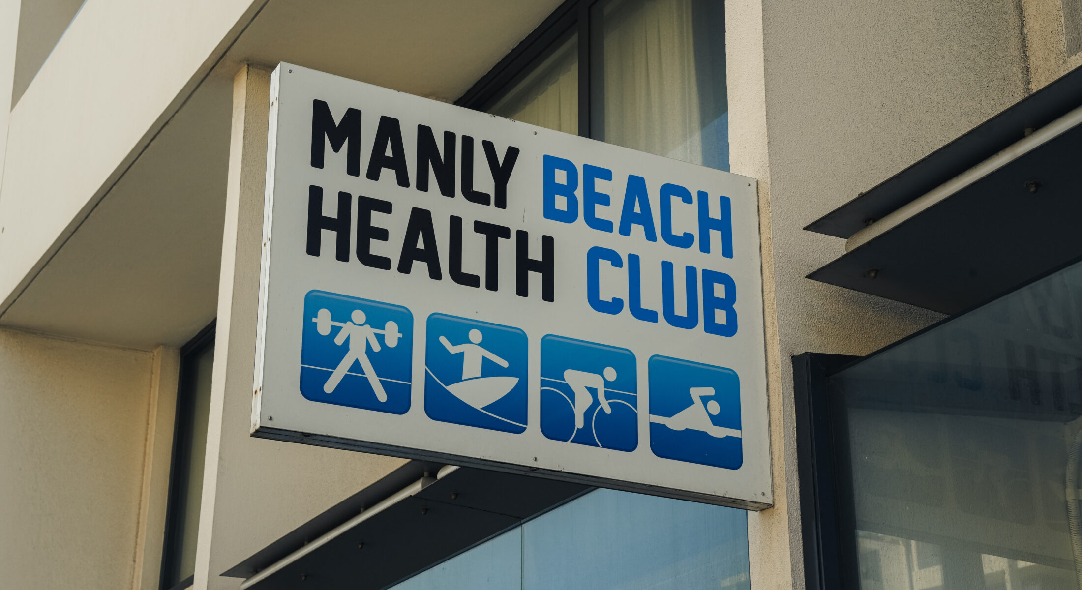 a sign that reads 'manly beach health club'.