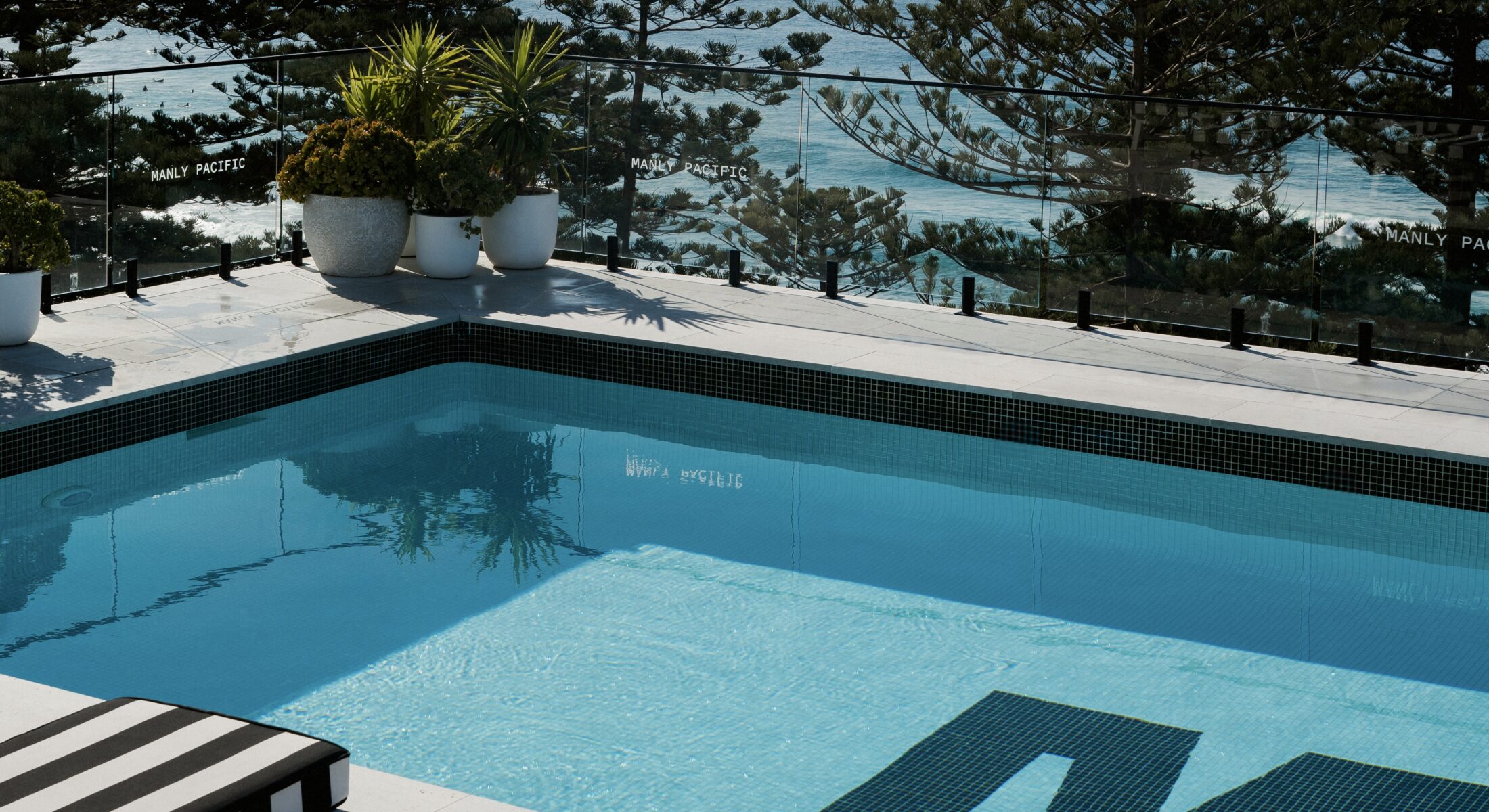Pool shot showing the Manly Pacific's sunbeds and iconic pool